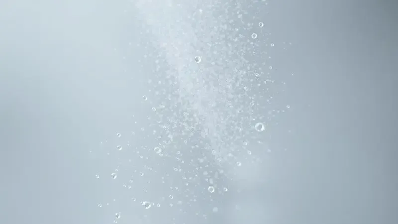 Representação artística em 3D de partículas de fragrância suspensas no ar com efeitos de luz cintilante.